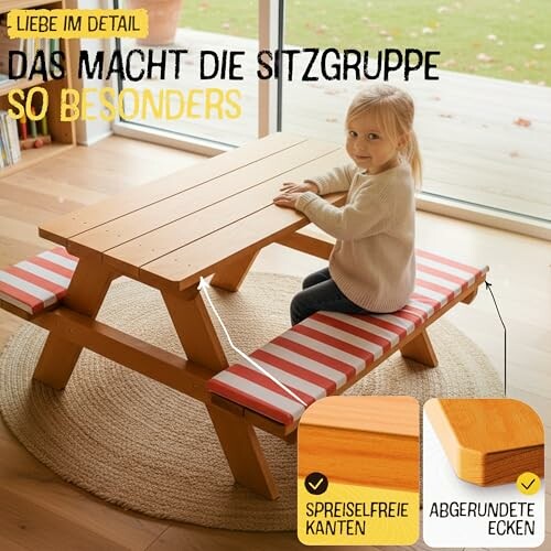 Kind sitzt an einem Picknicktisch aus Holz mit rot-weiß gestreiften Polstern.