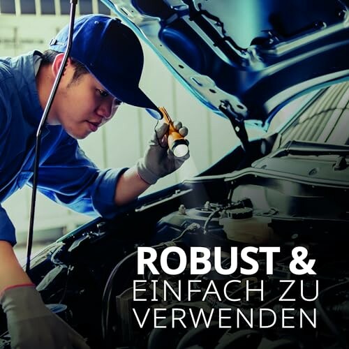 Mechaniker inspiziert Motor mit Taschenlampe.