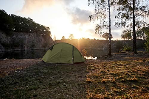 Zelt am Seeufer bei Sonnenuntergang.