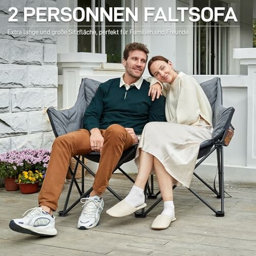 Ein Paar sitzt auf einem faltbaren Sofa im Freien.